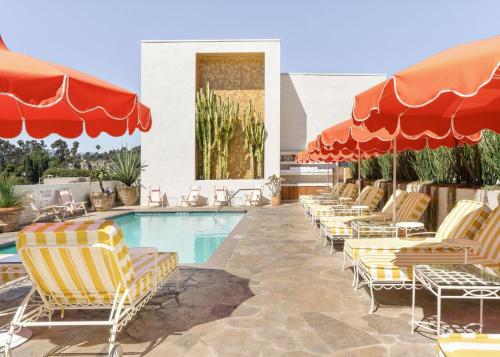 a swimming pool with lounge chairs and umbrellas at Silver Lake Pool & Inn in Los Angeles