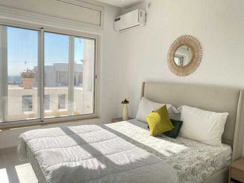 a bedroom with a bed and a large window at Panoramic 2 bedrooms Ennassr in Ariana