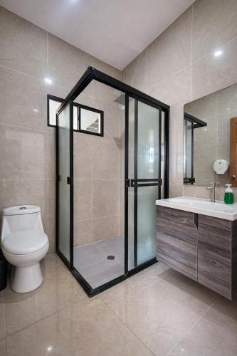 a bathroom with a shower and a toilet and a sink at Hotel Termaland in Atiquizaya