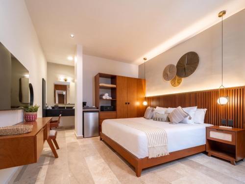a bedroom with a large bed and a kitchen at New Hotel Serenata Santa Lucia Mérida in Mérida