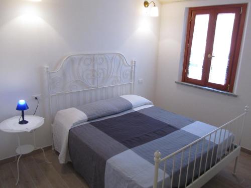 a white bedroom with a bed and a window at B&B La Casetta in Mondolfo