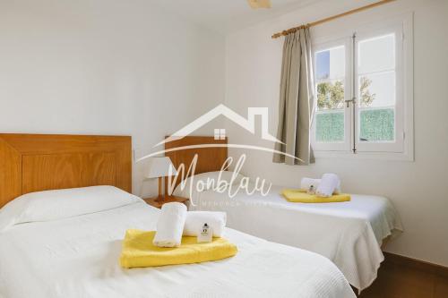 a bedroom with two beds with towels on them at Sa Torreta 1 in Cala Blanca