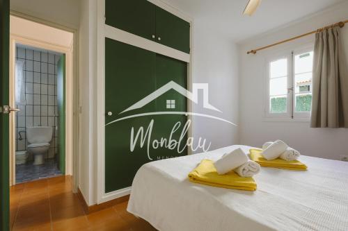 a bedroom with a bed with a green wall at Sa Torreta 1 in Cala Blanca