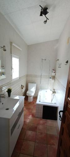 a bathroom with a tub and a toilet and a sink at Finca San Diego, villa entera para ti in Vallonga