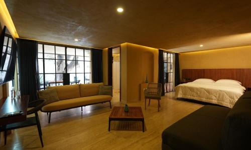a bedroom with a bed and a couch and a table at 7 Casa Laurel Hotel Boutique in Oaxaca City