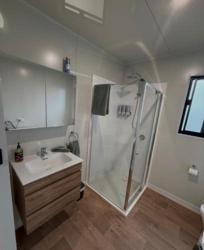 a bathroom with a shower and a sink at Peaceful Farm Retreat - Luxury Cabins in Goulburn in Norwood