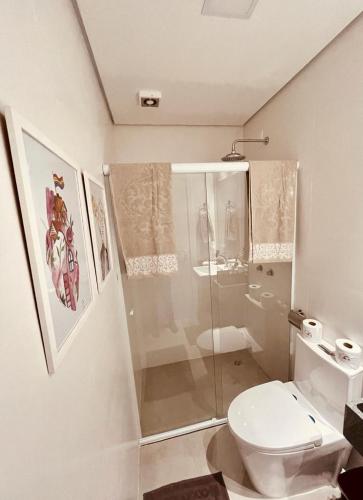 a white bathroom with a toilet and a shower at Flat Libertad, 404 A, com vaga de garagem in Pelotas