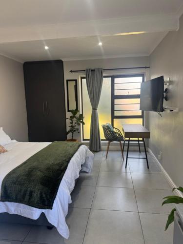 a bedroom with a bed and a desk and a television at The Apartment on Risa in Emerald Hill