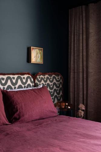 a bedroom with a bed with a purple comforter at Bon Bon Apt 5 - Tonka in Orange