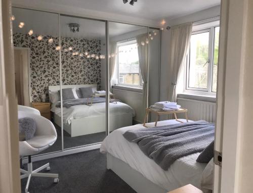 a bedroom with two beds and a mirror at fAiRy DeLL Guesthouse 24-7 check in, cozy lockable rooms, tv, tea tray with choccies, free wifi and parking, COA, all are welcome in Bradford