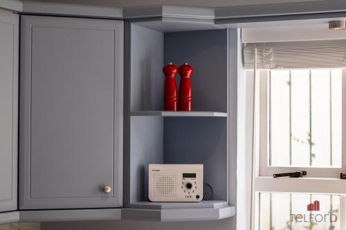 a room with red vases on shelves next to a window at Woodlodge Retreat in Holywood