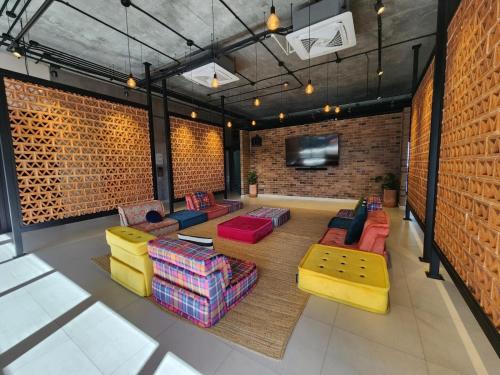 a living room with colorful furniture and a brick wall at Departamento Centro de monterrey Familiar con Alberca y Gym in Monterrey