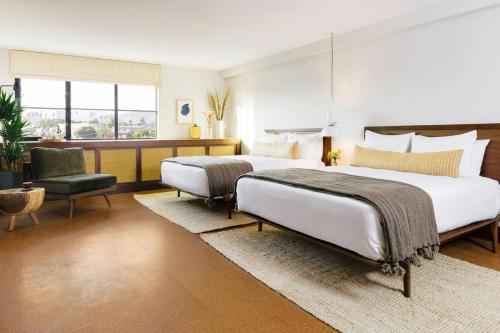 a bedroom with two beds and a chair at Silver Lake Pool & Inn in Los Angeles