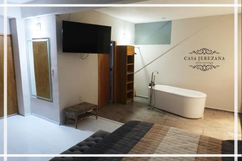 a bathroom with a tub and a tv and a bed at Casa Jerezana Hotel Boutique in Jerez de García Salinas