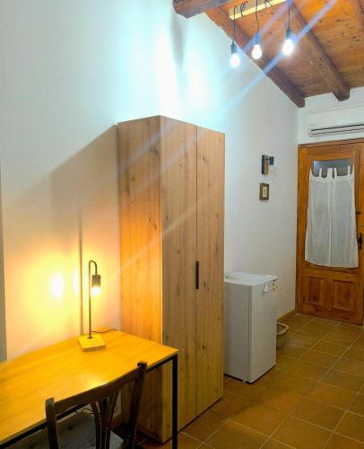 a room with a wooden table and a refrigerator at Agriturismo Casalicchio in Cammarata