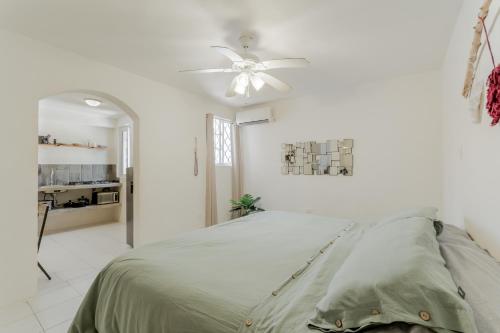 a white bedroom with a bed and a ceiling fan at Hermoso DEPARTAMENTO En El Centro Y Corazon DE CANCUN in Cancún