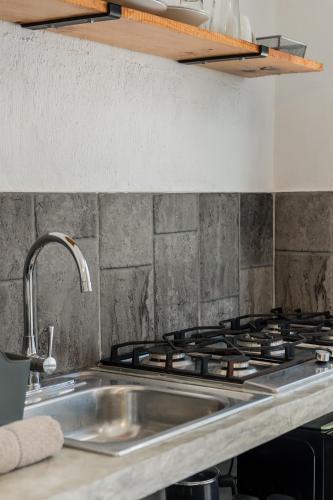 a kitchen counter with a sink and a stove at Hermoso DEPARTAMENTO En El Centro Y Corazon DE CANCUN in Cancún