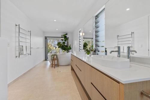 a bathroom with two sinks and a tub at Luxe on North Point in Kingscliff