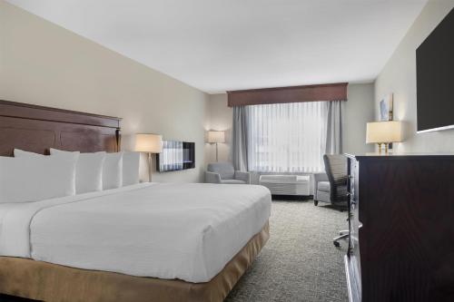 a hotel room with a bed and a television at Best Western Plus Grand-Sault Hotel & Suites in Grand Falls