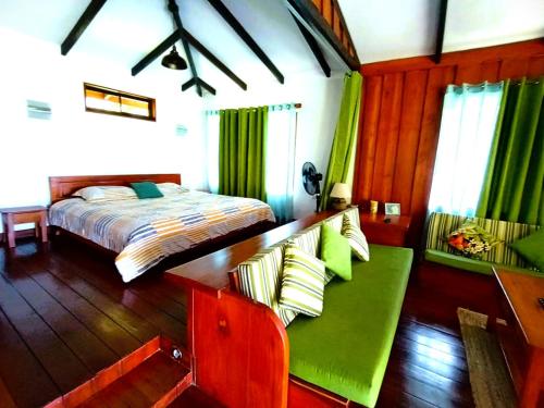 a bedroom with a bed and a green couch at Aloha Chirripo Lodge in Convento