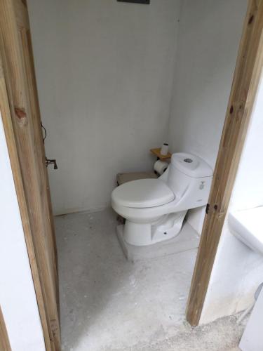 a bathroom with a white toilet in a room at Donde Dubon Pandi house in Puerto Jiménez