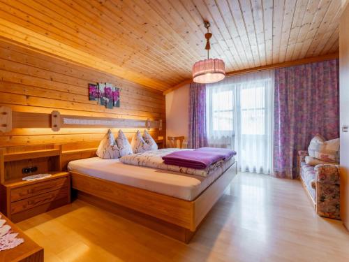 a bedroom with a large bed in a wooden room at Madreit in Leogang