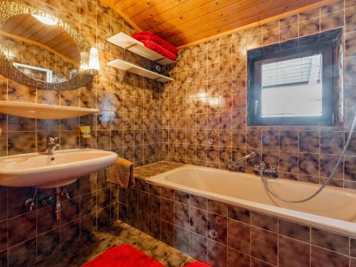 a bathroom with a sink and a tub and a mirror at Madreit in Leogang