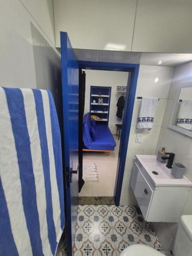 a bathroom with a blue and white toilet and a sink at Aconchego do Caju in Arraial do Cabo