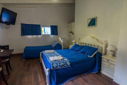 a bedroom with two beds and a desk and a television at La Posada del Sol in Torres