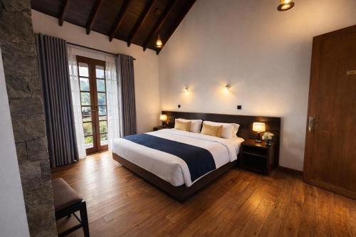 a bedroom with a large bed and a large window at The Ramp in Nuwara Eliya