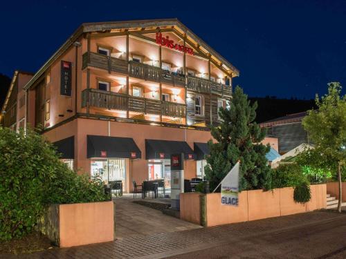 a large building with a balcony in front of it at ibis La Bresse Gérardmer in La Bresse