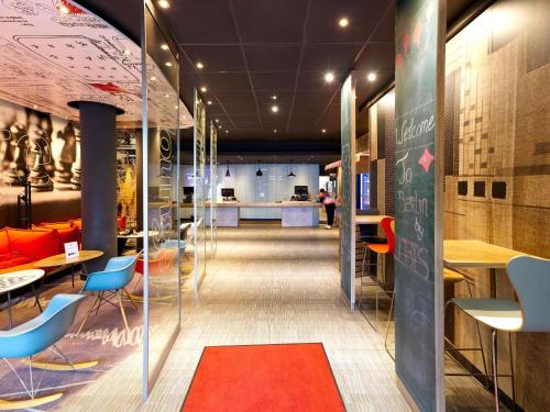 eine Lobby mit Stühlen und Tischen und einer Tafel in der Unterkunft ibis Berlin City Potsdamer Platz in Berlin
