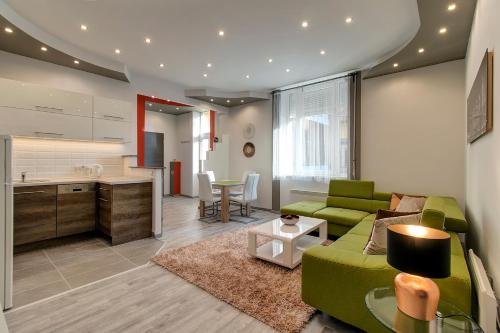 ブダペストにあるTamara Apartmentのリビングルーム(緑のソファ付)、キッチンが備わります。