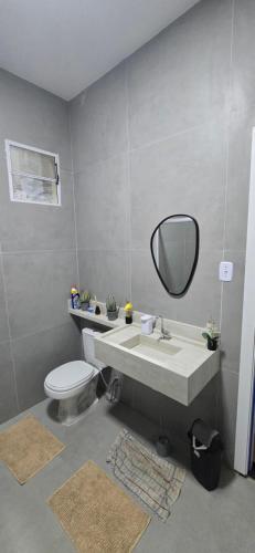 a bathroom with a sink and a toilet and a mirror at Girassol & Estética in Macapá