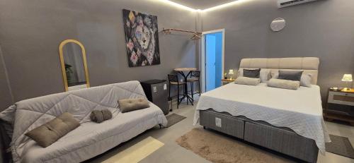 a bedroom with a bed and a couch in it at Girassol & Estética in Macapá