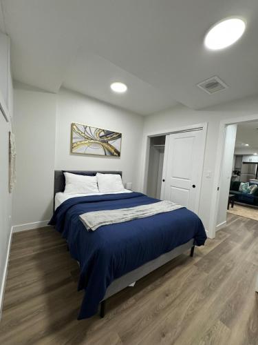 a bedroom with a bed with a blue blanket at Private Stylish Suite, Just Bring Your Bags in Edmonton