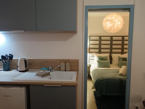 a kitchen with a sink and a bed in a room at Le Ptit Balu, Appartement en ville, proche de Bordeaux in Bègles