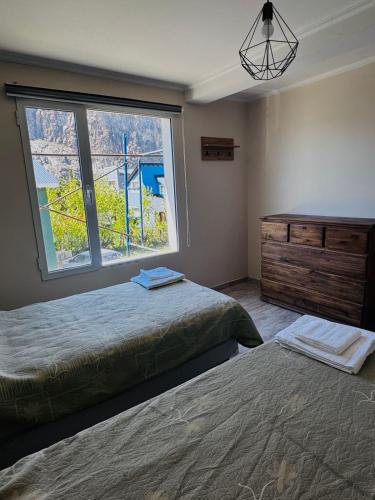 a bedroom with two beds and a large window at Brumas Patagónicas in El Chalten