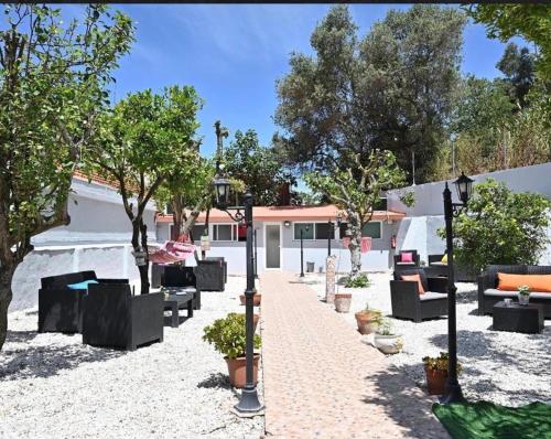 a patio with couches and trees in a yard at BrotherStay Rooms lusotile in Lisbon
