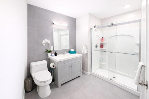 a white bathroom with a toilet and a shower at Modern Yale Loft Best Location Parking in New Haven