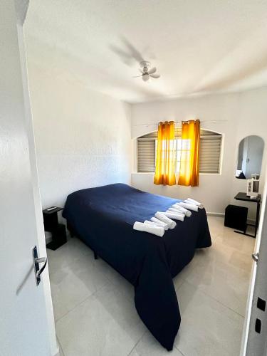 a bedroom with a blue bed with towels on it at CasaMara in Ribeirão Preto