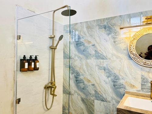 a bathroom with a shower with a glass door at Nuru House Stone Town Ensuite 3BR Apartment in Zanzibar City