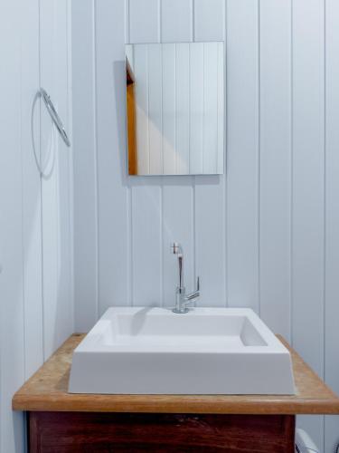 a bathroom with a white sink and a wooden counter at Vista do Lago Jungle Lodge in Cajual