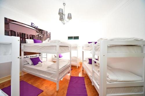 a room with three bunk beds with purple carpet at BrotherStay Rooms lusotile in Lisbon