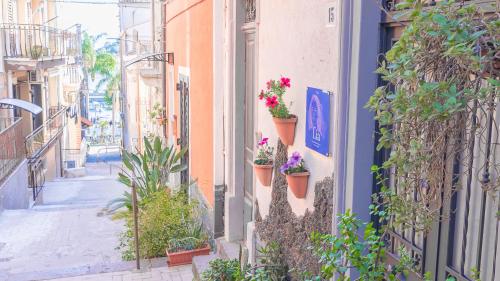 an alley with potted plants on the side of a building at Chibedda Dimora Lia in Acitrezza
