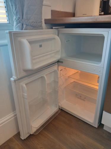an empty refrigerator with its door open in a kitchen at Harbour House Holiday Apartments in Bridlington