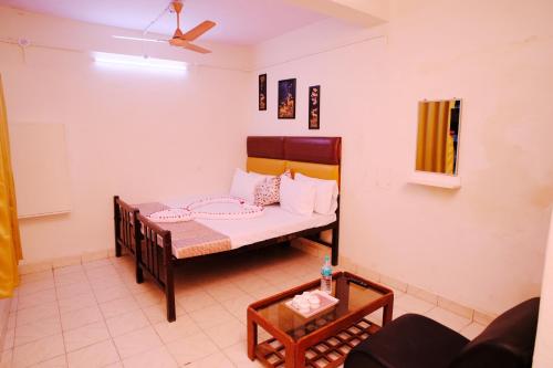 a small room with a bed and a table at Aruppukottai Nadar Lodge in Chennai