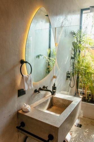 a bathroom with a large mirror and a sink at Villa Camila Tulum in Tulum