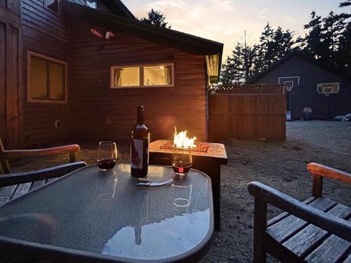 a table with a bottle of wine and two glasses at Quietside Studio - Fire Pit - Near Acadia in Southwest Harbor
