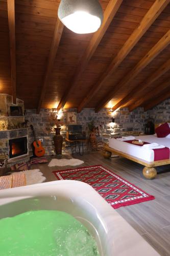 a room with a tub and a bed and a fireplace at Bujtina Kael in Librazhd